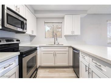 Bright kitchen featuring white cabinets, stainless steel appliances, and light countertops at 6871 Tamarus St # 204, Las Vegas, NV 89119