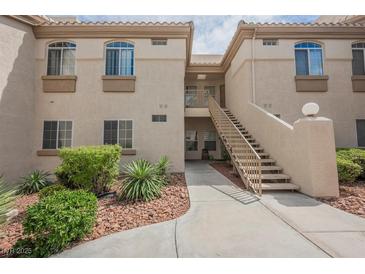 Inviting two-story condo building with well-kept landscaping, stairs and walkway to units at 7400 W Flamingo Rd # 1082, Las Vegas, NV 89147
