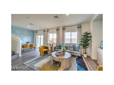 Bright living room showcasing modern furniture, large windows, and stylish decor with an adjacent dining area at 7915 Pandora Sky St # 402, North Las Vegas, NV 89084