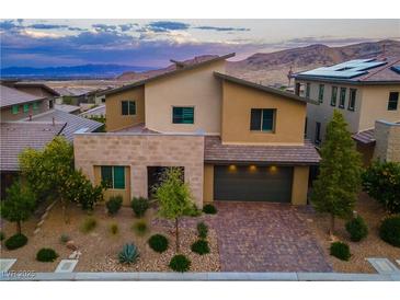 Contemporary two-story home featuring a brick driveway, desert landscaping, and mountain views at 12367 Aster Hills Ave, Las Vegas, NV 89138