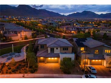 Beautiful aerial view of a desert home with stunning city and mountain views at twilight at 12404 Aster Hills Ave, Las Vegas, NV 89138