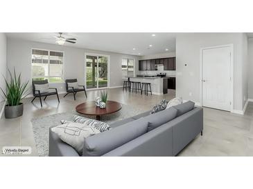 Bright living room featuring neutral tones and an open floor plan to the modern kitchen at 4512 Moon Hill Rock Ave, North Las Vegas, NV 89084