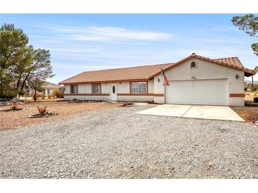 Charming single-story home with a tile roof, gravel yard, and attached two-car garage at 480 China St, Pahrump, NV 89048