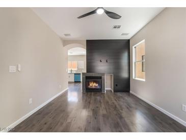 Bright living room features a fireplace with black accent wall and modern ceiling fan at 6260 Castle Kennedy St, Henderson, NV 89011