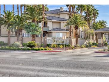 Beautiful condo exterior with mature landscaping, palm trees and signage at the entry to the community at 7155 S Durango Dr # 309, Las Vegas, NV 89113