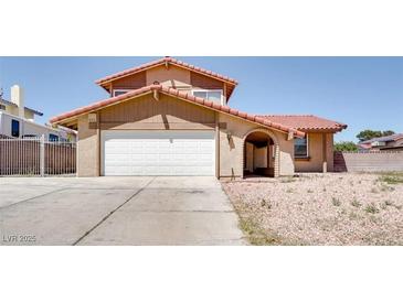 Charming two-story home featuring a red tile roof and an attached two-car garage in a sunny neighborhood at 864 E Eldorado Ln, Las Vegas, NV 89123