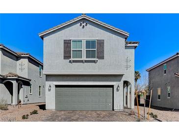 Charming two-story home with a gray exterior, a two-car garage, and a beautifully landscaped front yard at 8786 Sand Verbena Ave, Las Vegas, NV 89117