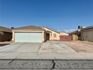 Single story home showcasing a large garage, a well-kept lawn, and a traditional desert landscape at 2621 Blue Reef Dr, North Las Vegas, NV 89032