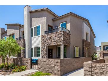 Attractive townhome featuring a stone facade, balcony, and a well-maintained front yard at 328 Owens Peak Dr, Henderson, NV 89015
