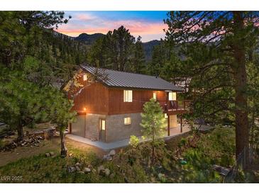 Stunning exterior view showcasing a charming two-story home nestled in a lush, wooded setting at 3971 Arlberg Way, Mount Charleston, NV 89124