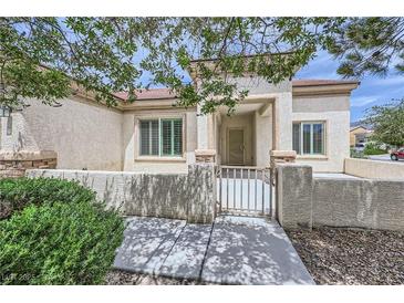 Charming single-story home featuring a gated front courtyard with stucco and brick accents at 7465 Widewing Dr, North Las Vegas, NV 89084