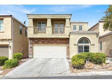 Two-story home with stone accents, a balcony, two-car garage, and a well-maintained front yard at 8015 Maple Park St, Las Vegas, NV 89131