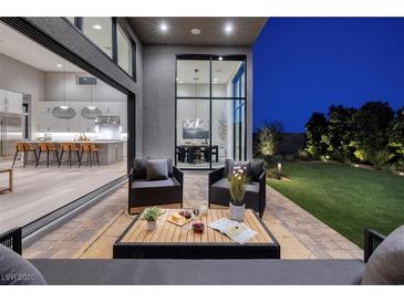 Inviting outdoor patio with comfortable seating and seamless transition to the modern kitchen at 10781 Agate Cliffs Ave, Las Vegas, NV 89135