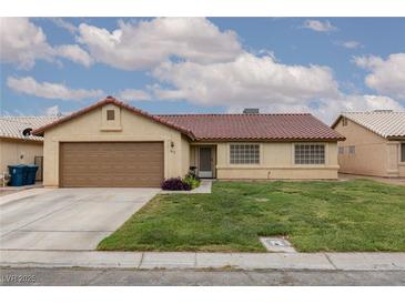 Charming single-story home featuring a red tile roof, a well-manicured lawn, and an attached two car garage at 1835 Banaba Ln, Las Vegas, NV 89156