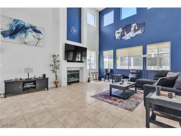 Open living room with high ceilings, fireplace, and lots of natural light at 217 Turkey Creek Way, Henderson, NV 89074