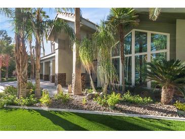 Stunning home exterior featuring lush landscaping and a modern architectural design with large windows at 2309 Prometheus Ct, Henderson, NV 89074