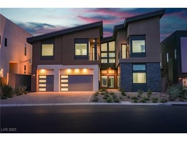 Striking modern home featuring a three car garage and contemporary architectural details at 5364 Succulent Rose Dr, Las Vegas, NV 89135