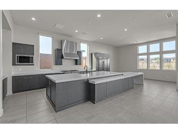 Bright kitchen boasts a large island, stainless steel appliances, modern cabinets, and views of the backyard at 5364 Succulent Rose Dr, Las Vegas, NV 89135