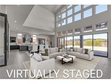 Bright, virtually staged living room with high ceilings, large windows, and open floor plan to kitchen at 5364 Succulent Rose Dr, Las Vegas, NV 89135
