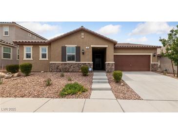 Charming single-story home featuring a stone veneer, desert landscaping, and a two-car garage at 705 Coastal Lagoon St, Henderson, NV 89002