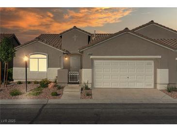 Charming single-story home with a two-car garage and landscaped front yard under a lovely sunset sky at 11082 Sospel Pl, Las Vegas, NV 89141