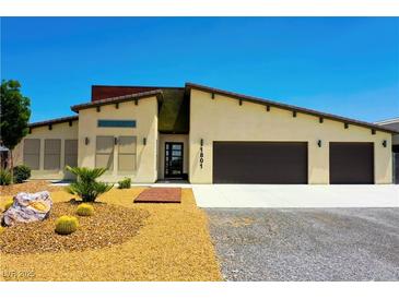 Beautiful single-story home featuring a modern design, three-car garage, and desert landscaping at 1801 S Manzanita Dr, Pahrump, NV 89048
