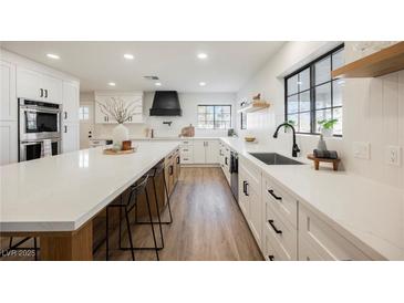 Modern kitchen featuring white cabinetry, black hardware, quartz countertops, and stainless steel appliances at 1917 N Moapa Valley Blvd, Logandale, NV 89021