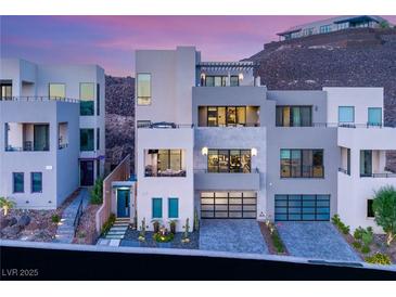 Striking three-story modern home with multi-car garage and manicured front yard at 358 Solitude Peak Ln, Henderson, NV 89012