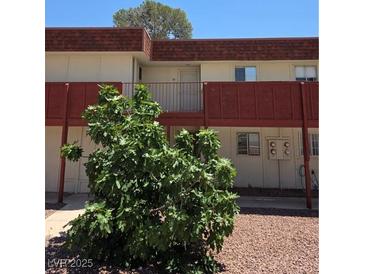 Exterior view of a multi-Gathering home with muted color scheme, a small balcony, and minimal landscaping at 5440 Swenson St # 18, Las Vegas, NV 89119