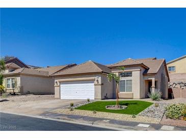 Tan single-story home with desert landscaping, attached two-car garage and concrete driveway at 177 Shaded Peak St, Henderson, NV 89012