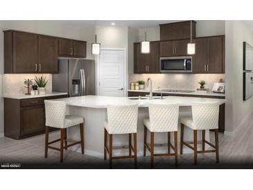 Modern kitchen boasts stainless steel appliances, dark wood cabinetry, and a large center island with barstool seating at 2607 Regency Cove Ct # Lot 11, Las Vegas, NV 89121