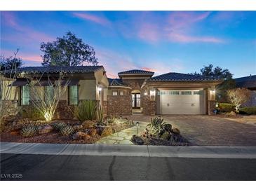 Beautiful single-story home featuring a stone pathway, desert landscaping, and a two-car garage at 2749 Liberation Dr, Henderson, NV 89044