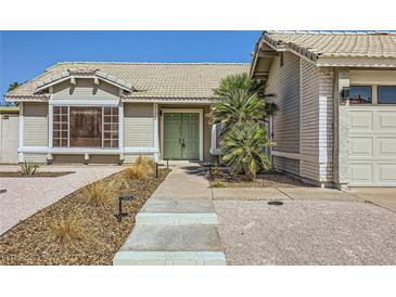 Charming single-story home featuring desert landscaping, a two-car garage, and a quaint front entryway at 335 Simon Bolivar Dr, Henderson, NV 89014