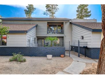 Charming home featuring a balcony, brick accents and metal fence, enhancing its curb appeal at 1600 Becke Cir, Las Vegas, NV 89104