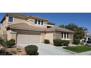 Charming two-story home featuring a two-car garage, brick accents, and manicured landscaping on a sunny day at 2384 Stansbury Ct, Henderson, NV 89052