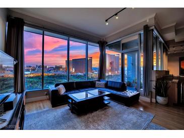 Stunning living room with a city view, floor-to-ceiling windows and modern black leather sectional at 360 E Desert Inn Rd # 1803, Las Vegas, NV 89109