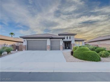 Beautiful single-story home featuring a three-car garage, desert landscaping, and a neutral color palette at 7225 Millerbird St, North Las Vegas, NV 89084