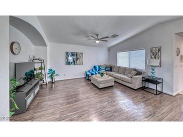 Spacious living room with vaulted ceilings, hard wood floors, and a comfortable, neutral-toned sofa at 8567 Little Fox St, Las Vegas, NV 89123