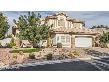Charming two-story home with a desert landscaped front yard and a driveway leading to a two-car garage at 9718 Camino Capistrano Ln, Las Vegas, NV 89147