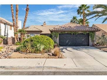 Charming single-story home featuring a low-pitch tile roof and well-maintained desert landscaping in a sunny setting at 1803 Candle Bright Dr, Henderson, NV 89074