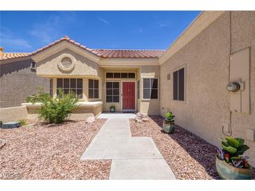 Charming single-story home featuring a red front door, desert landscaping and a tiled roof at 2420 Desert Butte Dr, Las Vegas, NV 89134