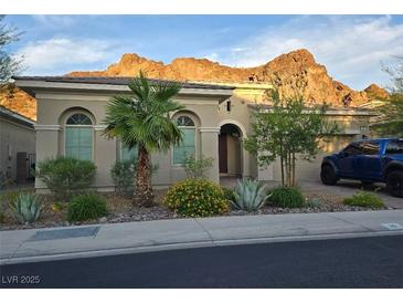 Charming single-story home with desert landscaping, mountain views, and a blue truck in the driveway at 26 Costa Tropical Dr, Henderson, NV 89011