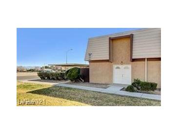 Two-story home featuring a covered parking area, a well-maintained lawn, and a symmetrical facade with a double-door entrance at 3441 Villa Way, Las Vegas, NV 89120