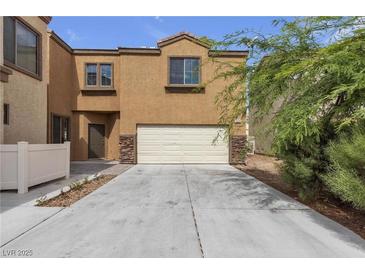Charming townhouse showcasing a two-car garage and desert landscaping at 6325 Orions Tool St, North Las Vegas, NV 89031