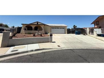 Charming single-story home featuring an arched front porch and a spacious driveway leading to a two-car garage at 7116 Bramble Ct, Las Vegas, NV 89145