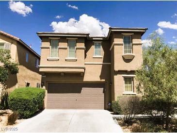Two story home with tan stucco, a two-car garage and a concrete driveway under a partly cloudy sky at 8550 Bright Bush St, Las Vegas, NV 89131