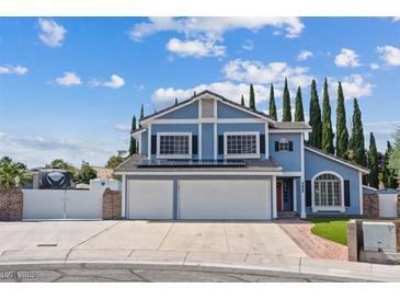 Charming two-story home with blue siding, black shutters, solar panels, and well-manicured lawn at 9436 Darwell Dr, Las Vegas, NV 89117