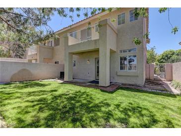 Lush backyard featuring a well-maintained lawn, brick accents, and a charming covered patio, perfect for outdoor relaxation at 108 Broken Rock Dr, Henderson, NV 89074