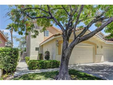 Charming townhouse showcasing a well-kept lawn and inviting two-car garage, with mature trees providing ample shade at 108 Broken Rock Dr, Henderson, NV 89074