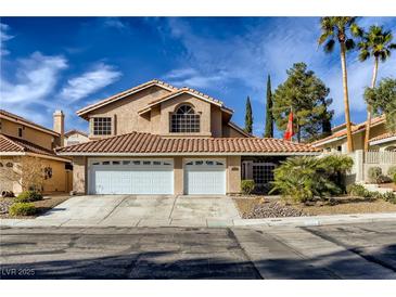 Charming two-story home with a red tile roof, three-car garage, and desert landscaping at 3355 Royal Bay Dr, Las Vegas, NV 89117